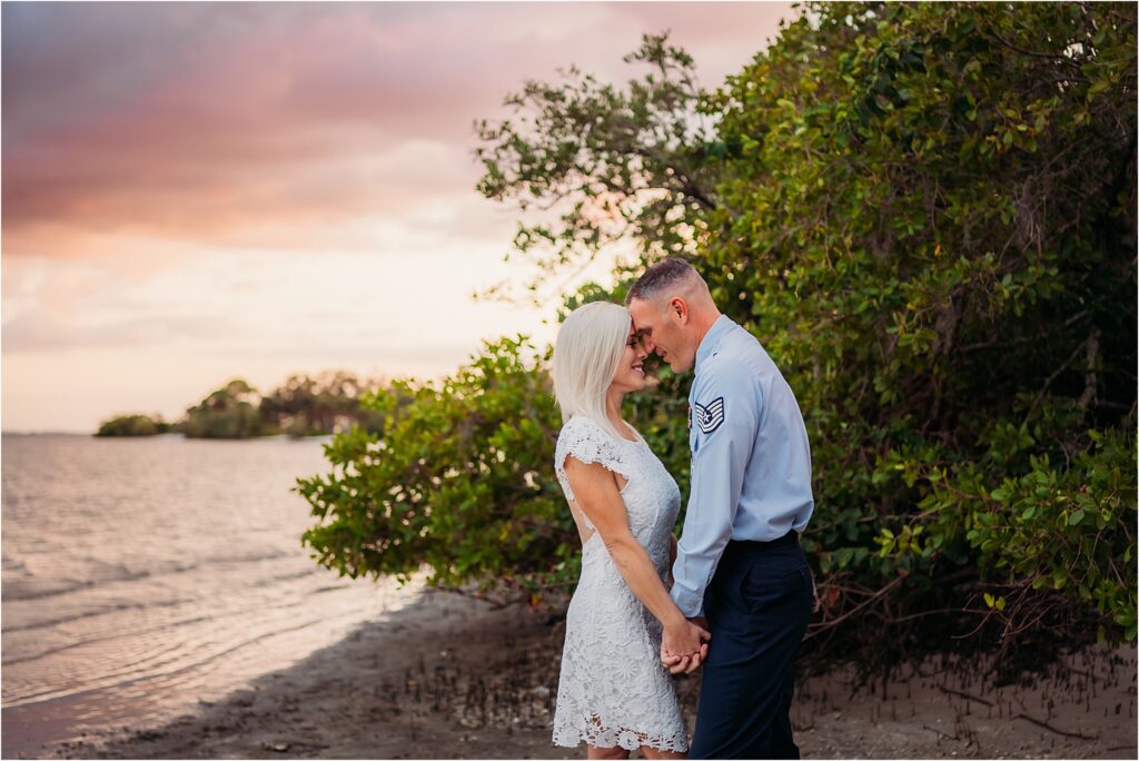 Newly married Husband and wife holding hands at sunset by the beach at Philippe Park Safety Habor near Tampa