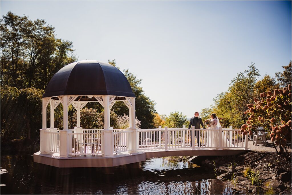 Rochester NY bridal couple embracing each other at Woodcliff Hotel & Spa during golden hour at sunset with warm florals and landscapes